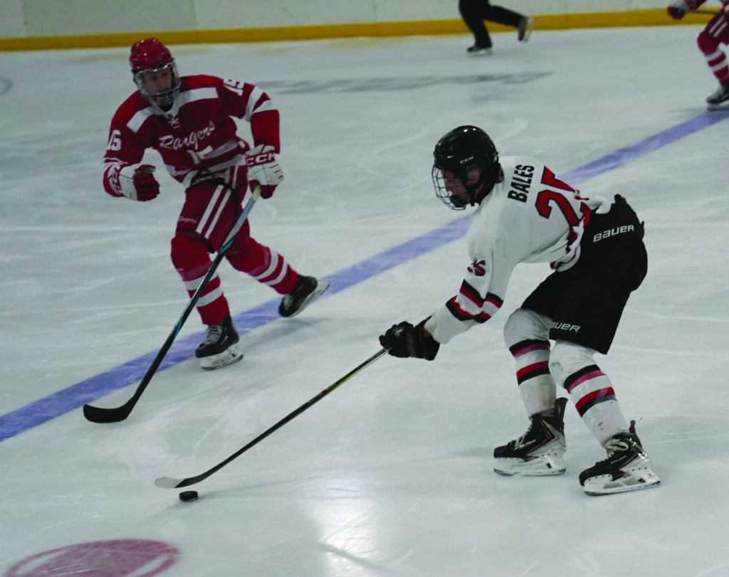 Huron’s Jace Bales handles the puck as he is pressured by Mauer Bartley of Brookings during their game Saturday at Bergman Arena.