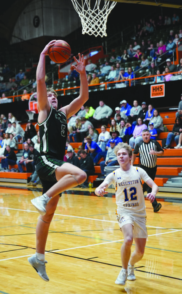 MIKE CARROLL/PLAINSMAN Chris Bevers of Clark/Willow Lake goes up for a shot against Tregen Jensen of Wessington Springs during their Huron Holiday Classic game on Dec. 30 at Huron Arena.