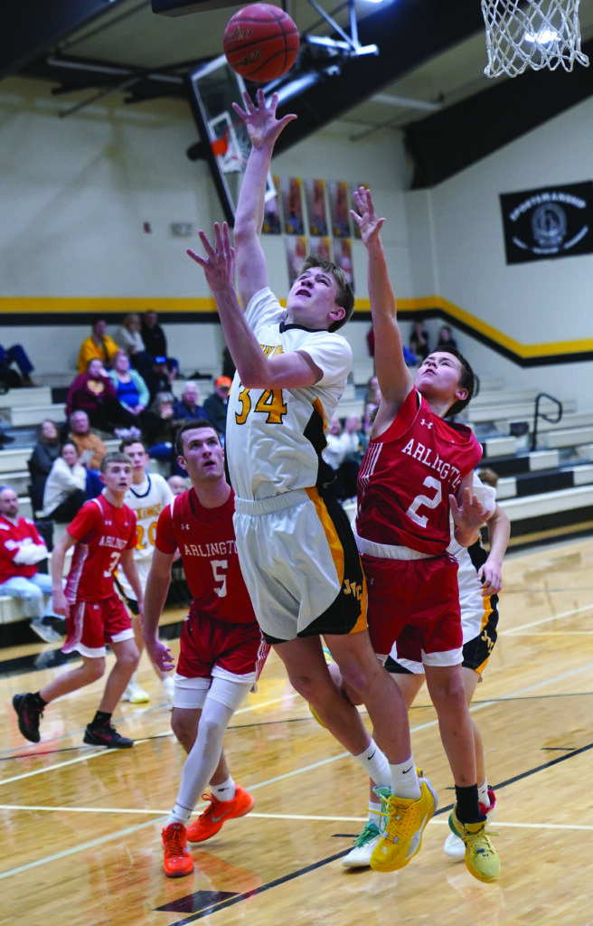 MIKE CARROLL/PLAINSMAN James Valley Christian’s Kyler Boomsma puts up a shot as Arlington teammates Paxton Rheault (5) and Max Josephsen (2) defend during their Region 2B play-in game Monday at the JVC gym.