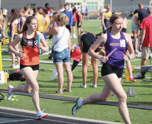 Hurons Ramsey Rozell looks to catch Watertowns Jayda Jensen during the final leg of the girls medley relay on Thursday at the Corn Palace Relays in Mitchell. Rozell would make the pass to claim sixth place for the Tigers
                                 Shaun Sarvis/Plainsman