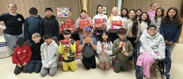 Courtesy photo Members of Holy Trinity Student Council and Holy Trinity 5th graders are pictured with Jenn Bragg, director of the Heartland Area Backpack Program.
