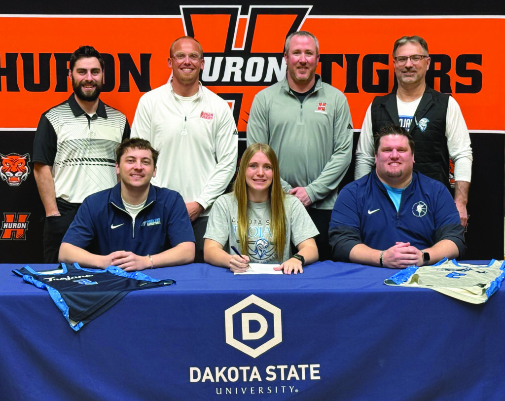 Benjamin Chase/Plainsman Back row, left to right, are brother Houstyn Heinz, Huron assistant coach Schuyler Holtrop, Huron head coach Kody Kopfmann, father Dennis Heinz. Front row, left to right, are Dakota State assistant coach Jacob Strand, Hylton, and Dakota State head coach David Moe.